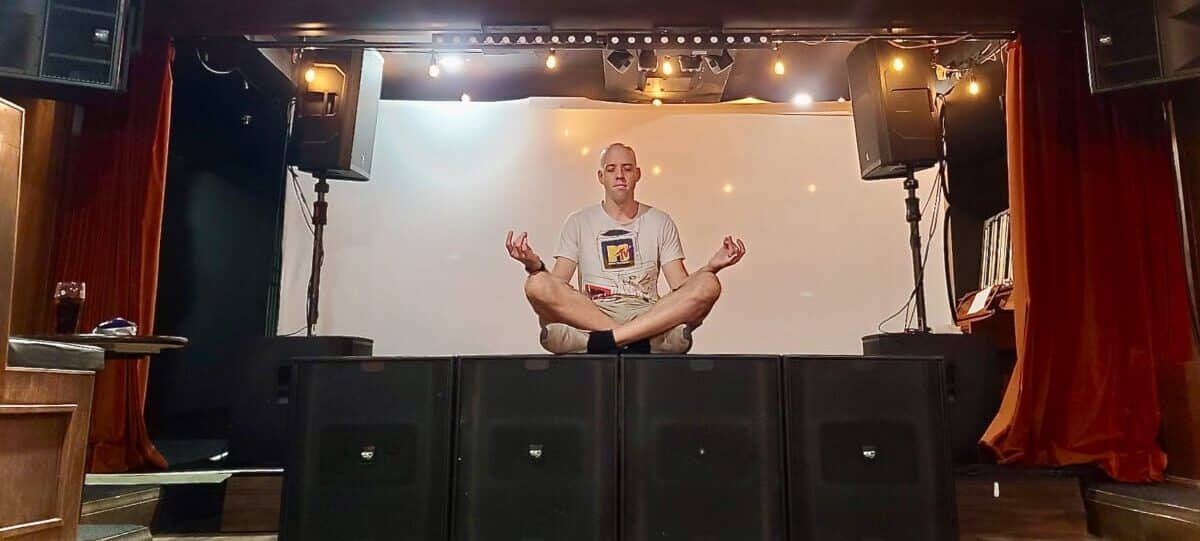 Man sitting in lotus position on speakers