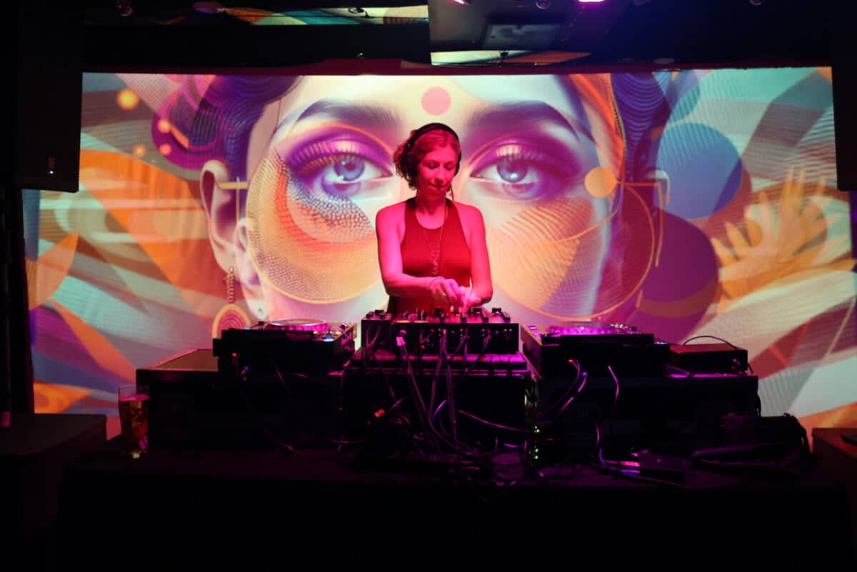 DJ in red light with AI video backdrop