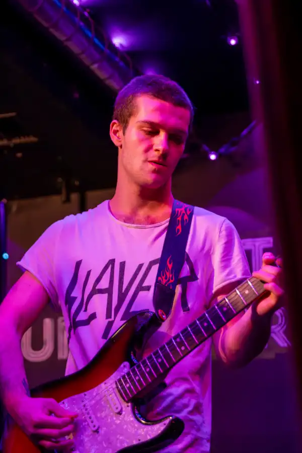 Man singing with guitar with slayer t-shirt